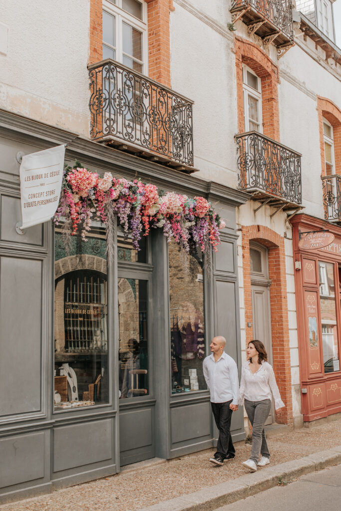 Un couple se promène dans le Centre Ville De Saint Lunaire. Un lieu de rencontre au coeur de la station balnéaire avec des boutiques indépendantes et des commerces de proximité.