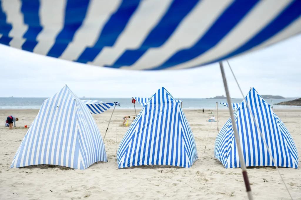 Tentes de Dinard aux rayures blanches et bleues dressées sur la plage de l'écluse en juillet et août. Crédit : A. Lamoureux