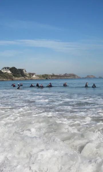 Un groupe de personnes pratique le longe côte à Saint-Lunaire. Cette activité sportive et nautique revigorante est très appréciée et pratiquée toute l'année. Photo : Sports mer santé.