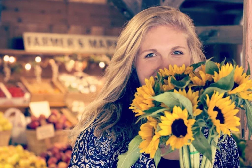 Marchés et Brocantes de la Côte d'Emeraude. Une femme tient un bouquet de fleurs achetés au marché.
