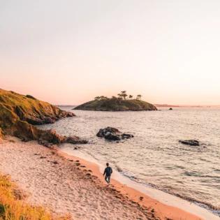 Le littoral de Saint-Briac-sur-Mer vue depuis le GR34. Un homme se promène face à L'îlot du Perron et sur la plage du Port au Chevaux.