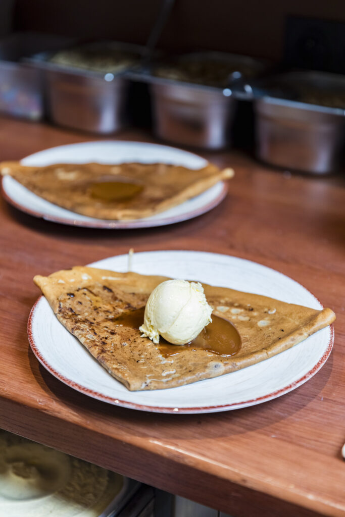 Photo d'une crêpe gourmande au caramel au beurre salé et une boule de glace de la Crêperie du Roy. Une crêperie traditionnelle bretonne située à Dinard. Photo : Studio Jezequel