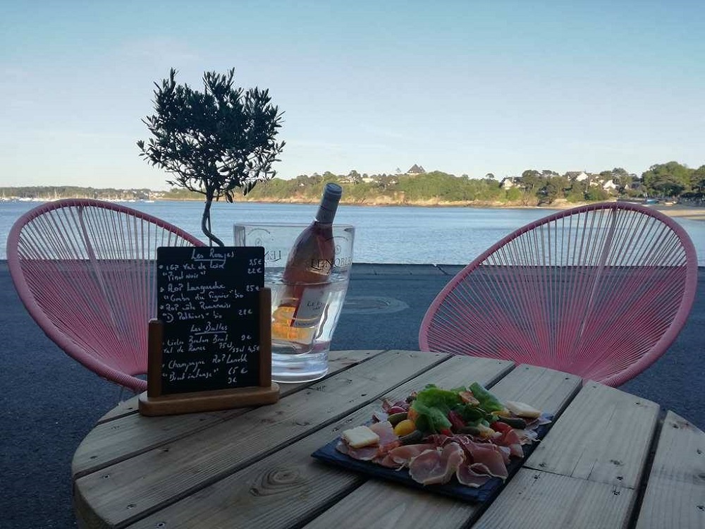 Planche à partager et une bouteille de vin servis au Carthagène, bar et restauration sur le pouce situé sur la plage du Prieuré à Dinard.