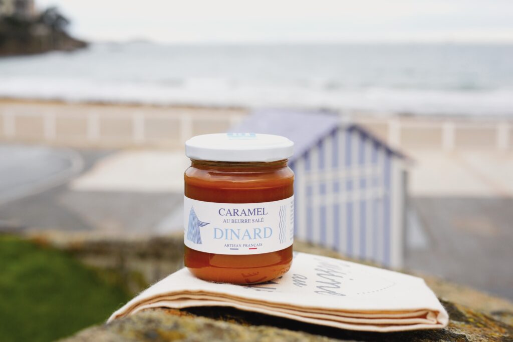 Caramel Dinard - un pot de caramel est posé devant la plage de l'Écluse.