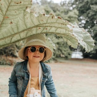 Pleurtuit - le printemps sur la Côte d'Émeraude. Une petite fille joue dans les feuilles du jardin de Montmarin